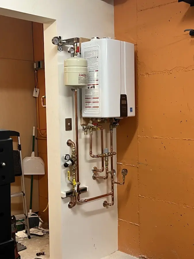 Plumbing technician inspecting water heater connections in Brick